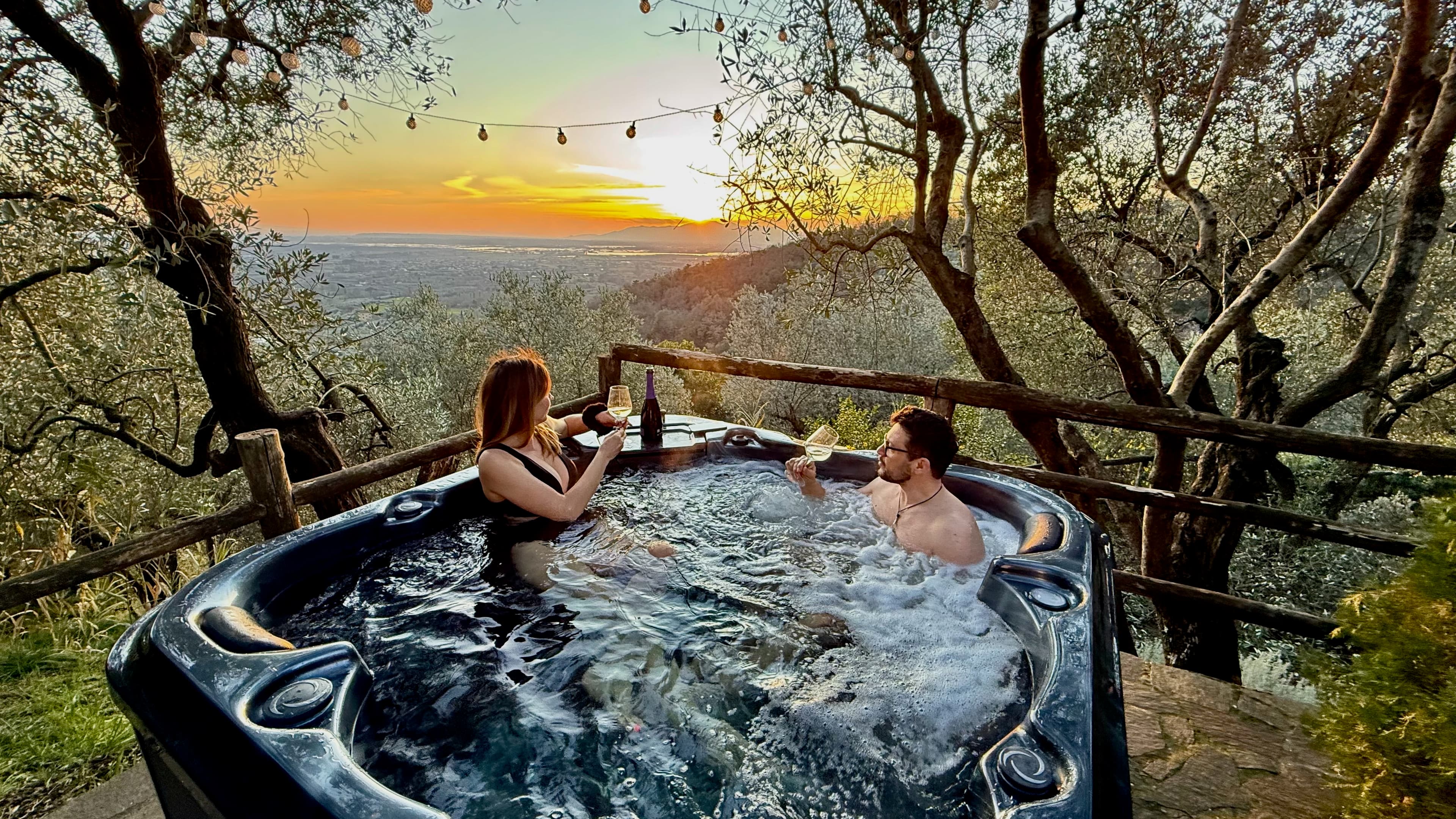 Outdoor jacuzzi spa area at Aura Toscana surrounded by natural landscape and Tuscan countryside views